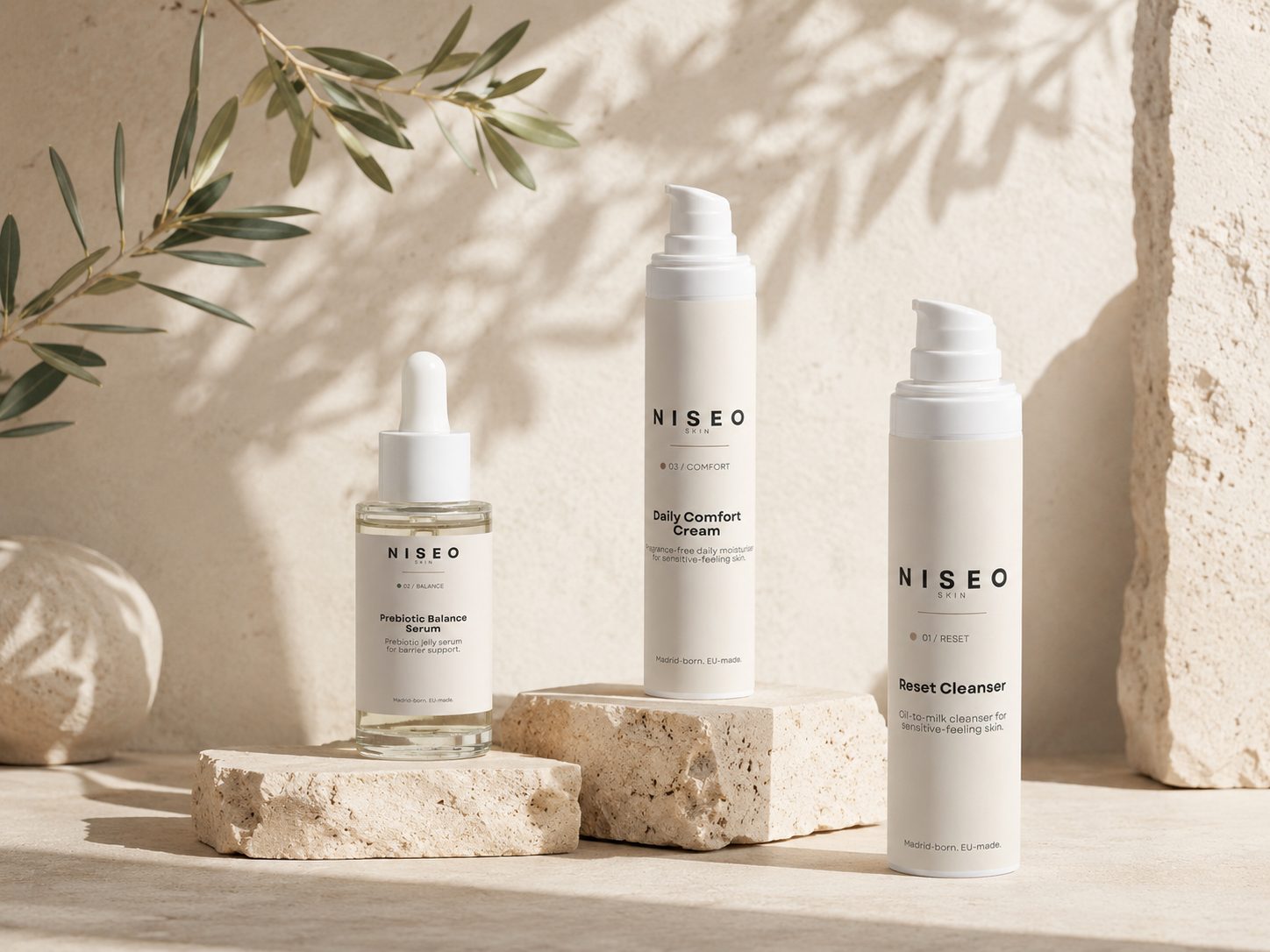 The NISEO Skin routine — Reset Cleanser, Prebiotic Balance Serum and Daily Comfort Cream on travertine stone in soft light